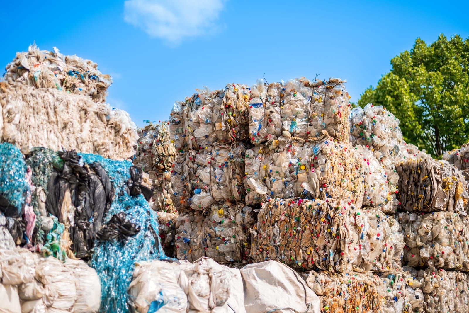 Balas de plástico prensado apiladas a la entrada de una planta de reciclaje